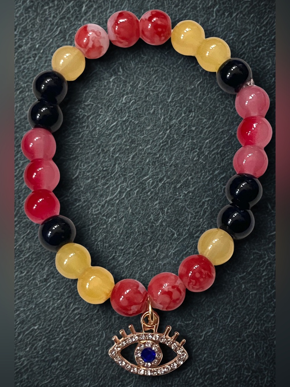 Gold All seeing eye charm/ black red and yellow glass beaded bracelet handmade